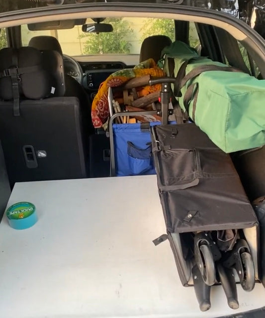 The view of Alissa’s trunk of their car with market supplies such as tables, a pop up, and a pack and play for her baby.